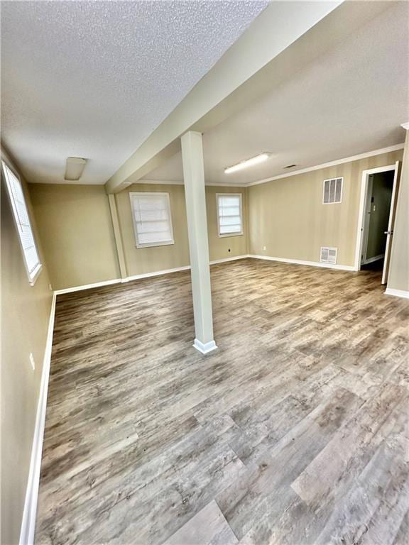 basement featuring a textured ceiling and wood-type flooring