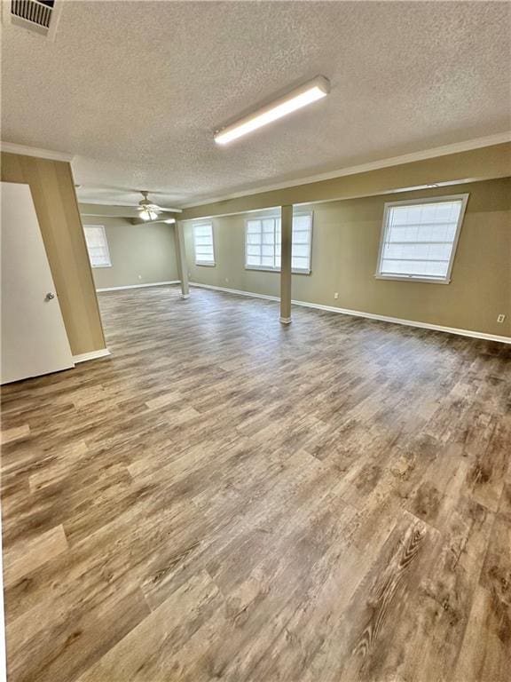 basement with wood-type flooring, ceiling fan, and a textured ceiling