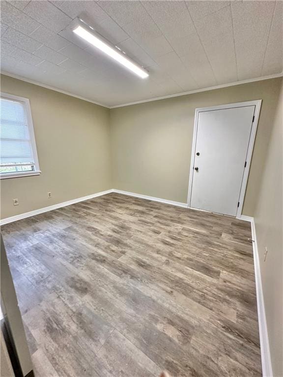 empty room with crown molding and hardwood / wood-style floors