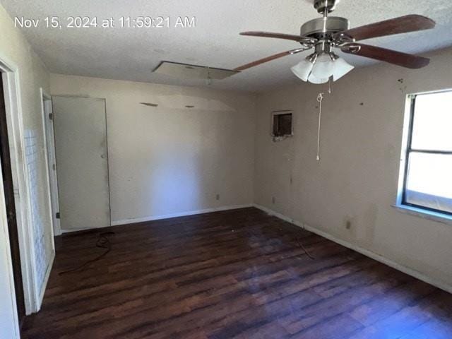 spare room featuring a textured ceiling, ceiling fan, and dark wood-type flooring