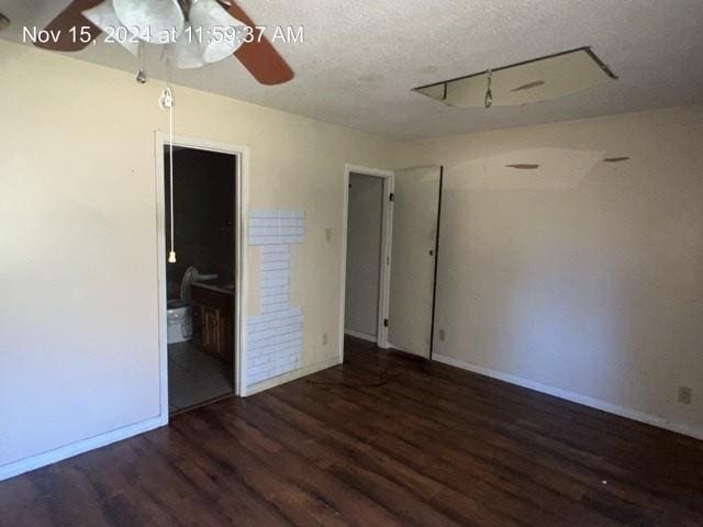 unfurnished room with ceiling fan, dark wood-type flooring, and a textured ceiling