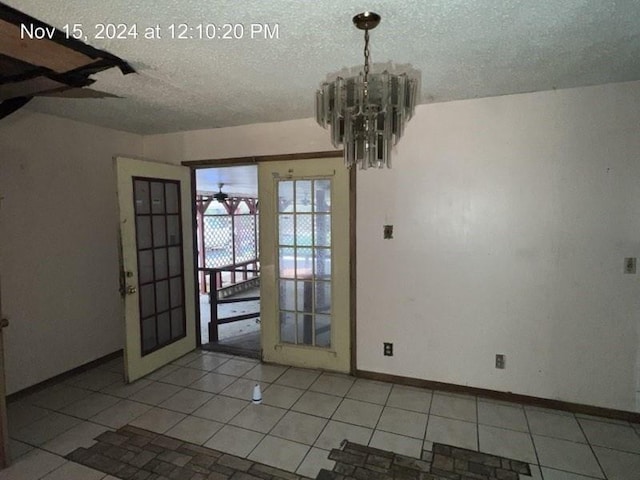 interior space featuring light tile patterned floors, a textured ceiling, and an inviting chandelier