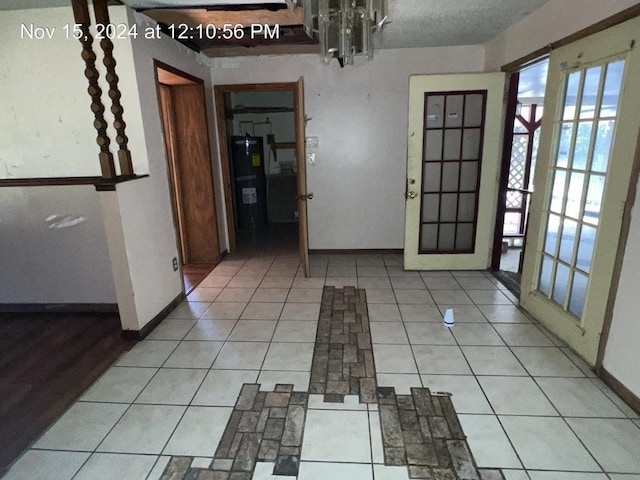 entryway with an inviting chandelier, light tile patterned floors, and water heater