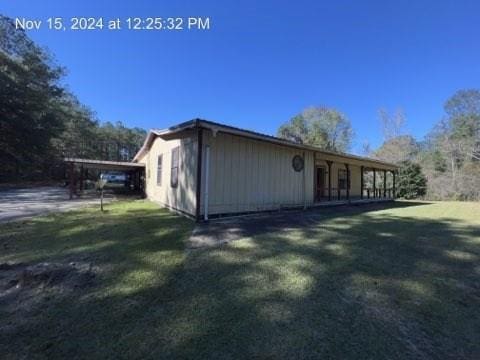 view of side of property featuring a yard and a carport