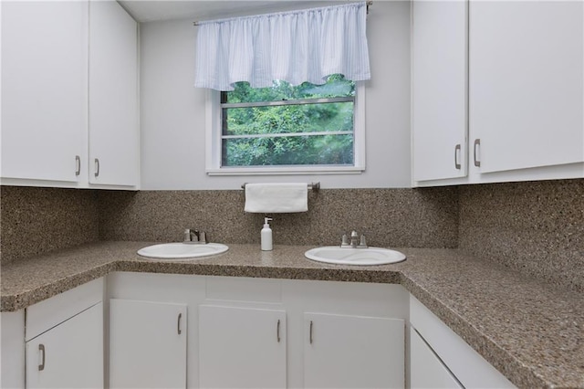 6659 Viking Way, Mobile, AL 36582 - kitchen with white cabinetry, decorative backsplash, and dark countertops