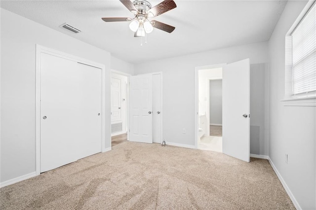 unfurnished bedroom featuring ensuite bath, ceiling fan, and carpet flooring