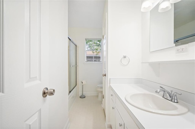 full bathroom with toilet, vanity, and bath / shower combo with glass door