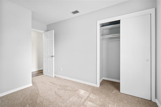 unfurnished bedroom featuring carpet and a closet