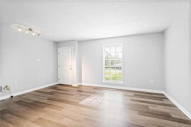 empty room featuring wood-type flooring and a textured ceiling