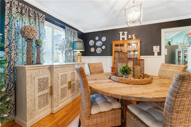 dining area featuring light wood-type flooring and ornamental molding