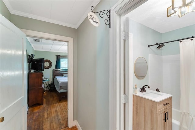 bathroom with crown molding, vanity, shower / bath combo with shower curtain, and wood-type flooring