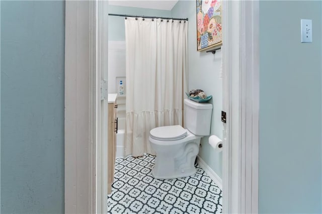 full bathroom featuring toilet, shower / bath combo with shower curtain, tile patterned floors, and vanity