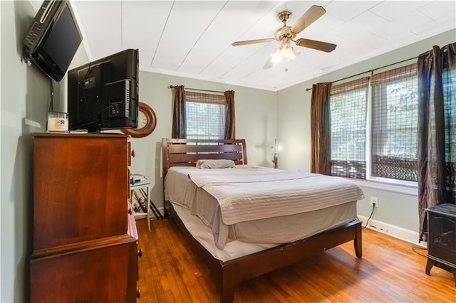 bedroom featuring ceiling fan, crown molding, and dark hardwood / wood-style floors