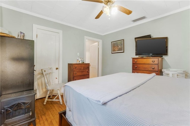 bedroom with ceiling fan, crown molding, and light wood-type flooring