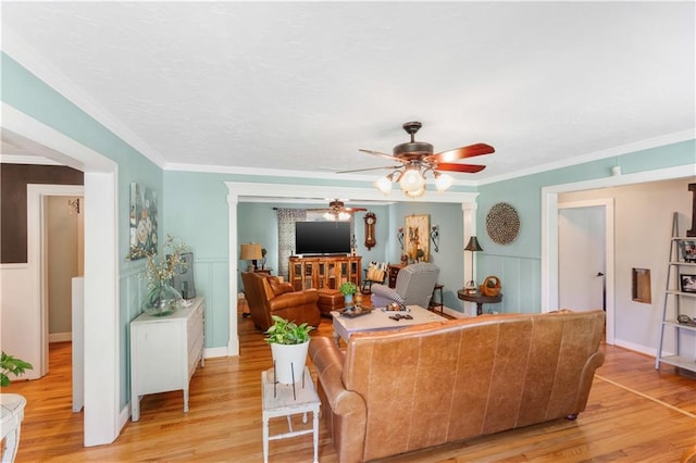 living room with ceiling fan, light hardwood / wood-style floors, and ornamental molding