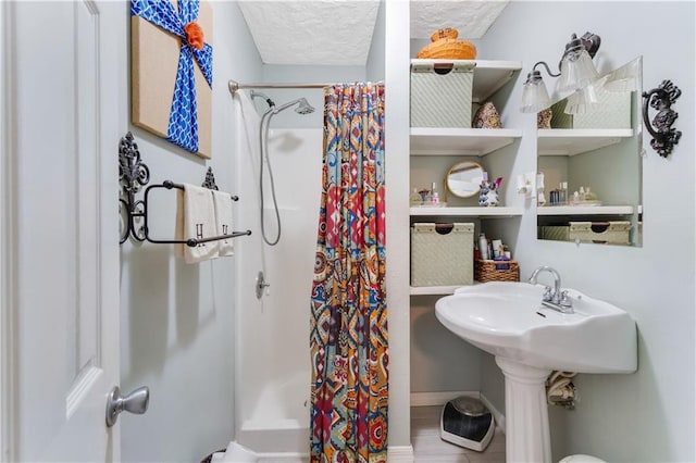 bathroom with a textured ceiling and a shower with curtain