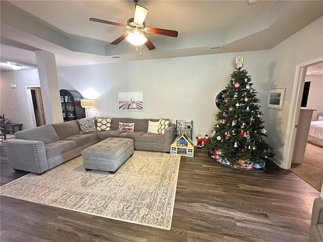 living room with ceiling fan and dark wood-type flooring