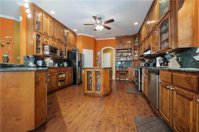 2765 Knollwood Dr, Mobile, AL 36693 - kitchen with appliances with stainless steel finishes, brown cabinetry, ornamental molding, arched walkways, and recessed lighting