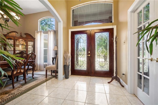 2765 Knollwood Dr, Mobile, AL 36693 - entrance foyer featuring french doors, light tile patterned floors, a towering ceiling, arched walkways, and baseboards