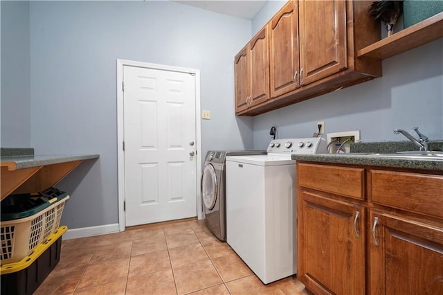 2765 Knollwood Dr, Mobile, AL 36693 - laundry area featuring independent washer and dryer, cabinet space, light tile patterned floors, and baseboards