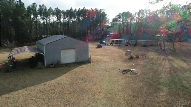 view of yard with a garage, an outdoor structure, and a carport