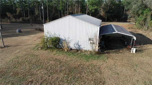 view of outbuilding featuring a carport and a lawn