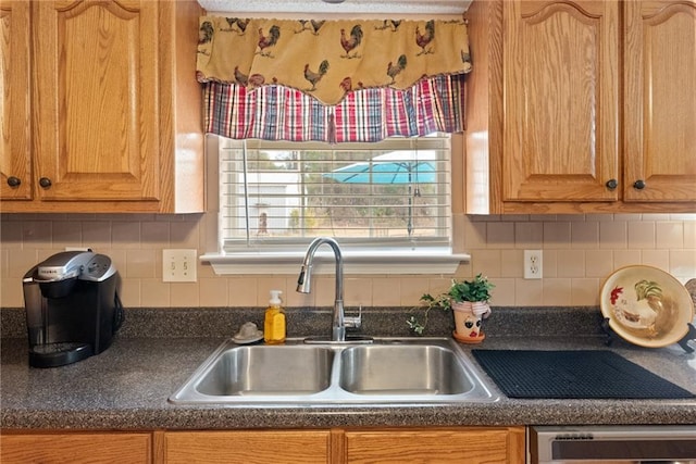 kitchen featuring tasteful backsplash, dishwashing machine, and sink