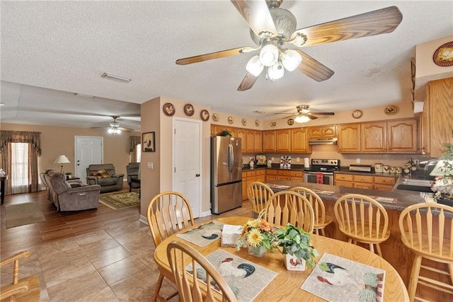 dining room with sink, light tile patterned floors, and a textured ceiling