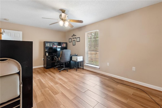 home office featuring ceiling fan, a textured ceiling, and light wood-type flooring