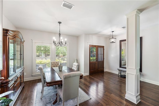 dining space featuring dark wood-type flooring, a chandelier, visible vents, and baseboards