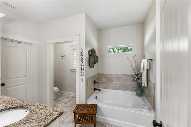 bathroom featuring a garden tub, toilet, visible vents, and vanity