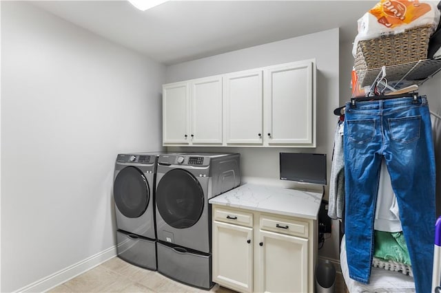 laundry area with washing machine and clothes dryer, cabinet space, and baseboards