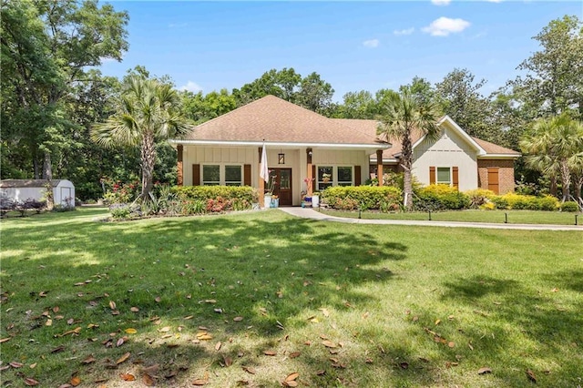view of front of house with an outdoor structure, a front yard, and a shed