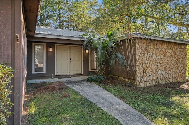 entrance to property featuring a lawn