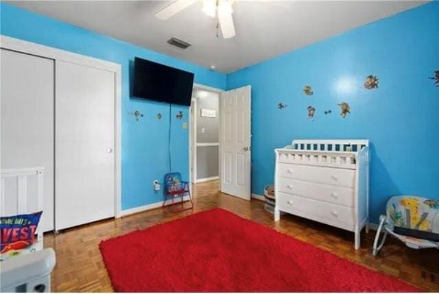 bedroom with ceiling fan, parquet floors, and a closet