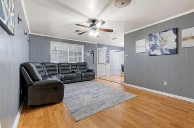 living room with crown molding, light hardwood / wood-style flooring, and ceiling fan