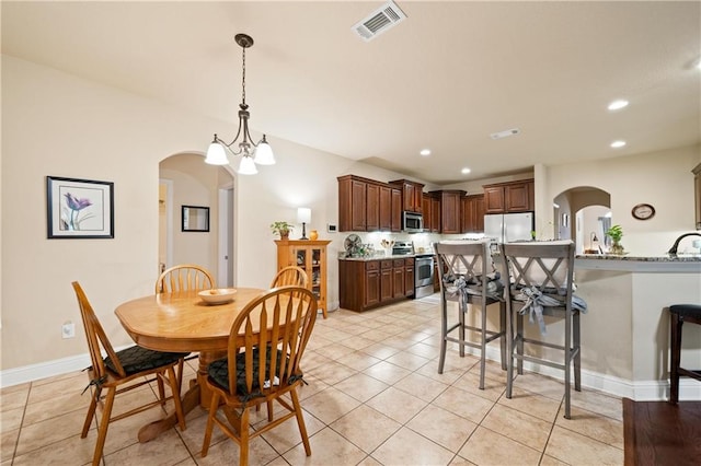 dining area featuring a notable chandelier and light tile patterned flooring