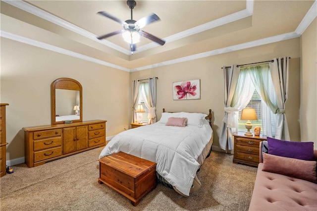 carpeted bedroom with a raised ceiling, ceiling fan, and crown molding