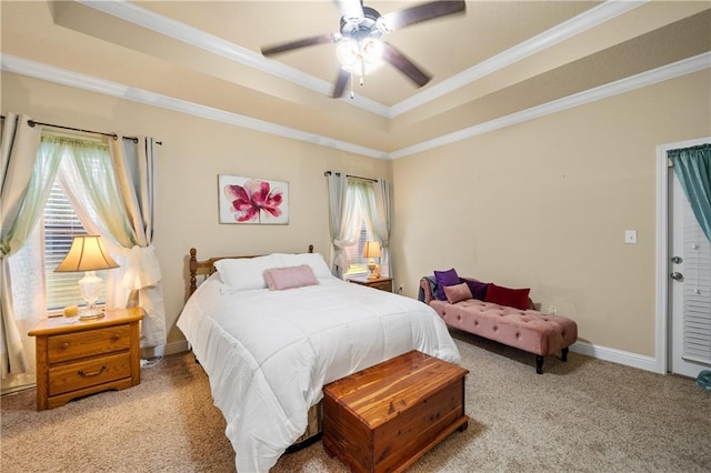 carpeted bedroom with a tray ceiling, ceiling fan, and ornamental molding