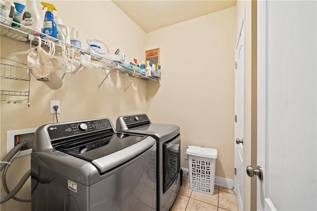 washroom featuring washing machine and clothes dryer and light tile patterned flooring