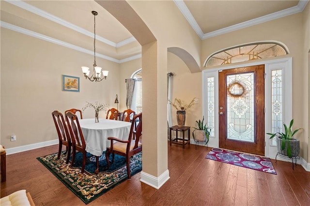 entrance foyer featuring dark hardwood / wood-style floors, an inviting chandelier, and crown molding