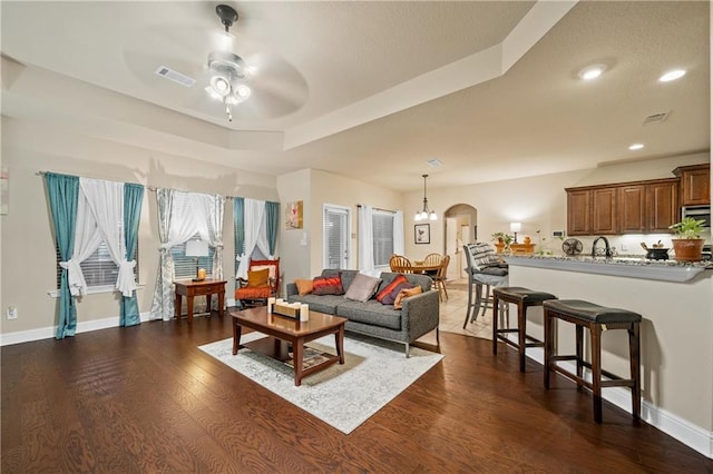 living room with dark hardwood / wood-style flooring and ceiling fan