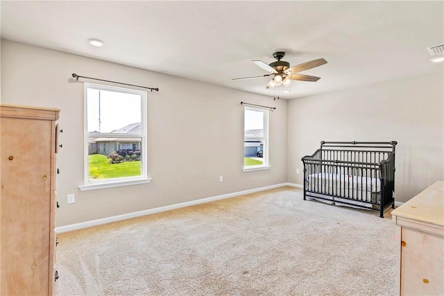 unfurnished bedroom with a crib, carpet, and baseboards