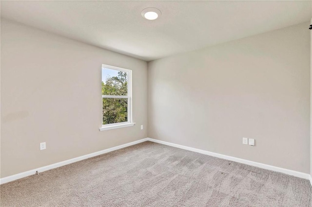 carpeted empty room featuring baseboards