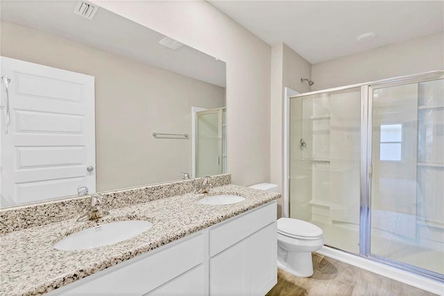 bathroom with a shower stall, a sink, visible vents, and toilet
