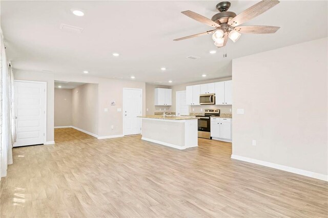unfurnished living room with recessed lighting, light wood-style floors, baseboards, and a ceiling fan