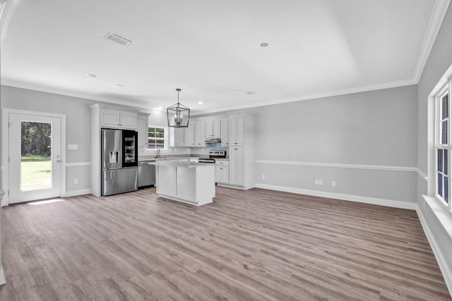 21621 Coleman Cemetery Rd, Moss Point, MS 39562 - kitchen featuring appliances with stainless steel finishes, a kitchen island, baseboards, open floor plan, and light wood finished floors