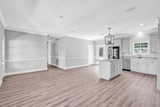 21621 Coleman Cemetery Rd, Moss Point, MS 39562 - kitchen featuring appliances with stainless steel finishes, open floor plan, light wood-style flooring, a kitchen island, and a sink
