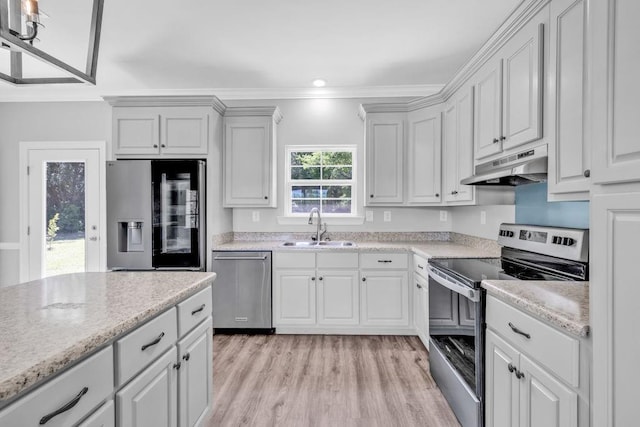 21621 Coleman Cemetery Rd, Moss Point, MS 39562 - kitchen with stainless steel appliances, a sink, under cabinet range hood, light wood-type flooring, and crown molding