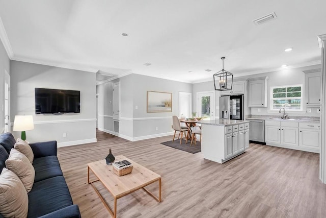 21621 Coleman Cemetery Rd, Moss Point, MS 39562 - living room featuring light wood-type flooring, baseboards, crown molding, recessed lighting, and a chandelier